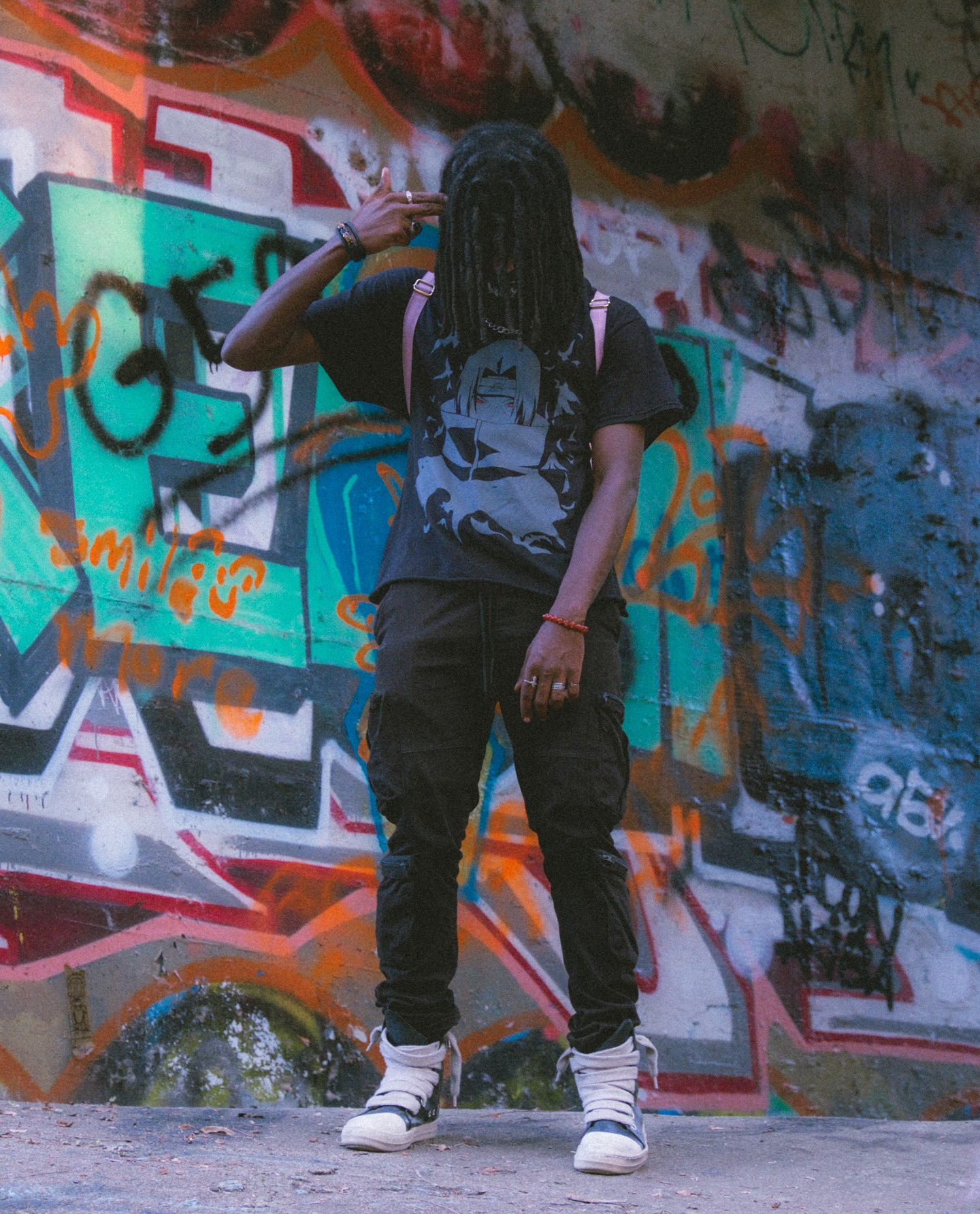 Person standing in front of a colorful graffiti wall