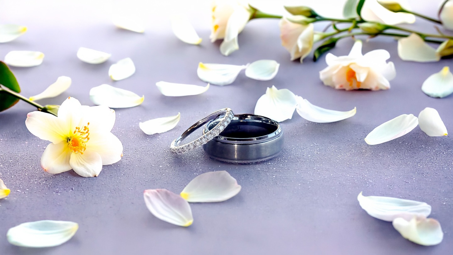 Wedding rings among white flower petals