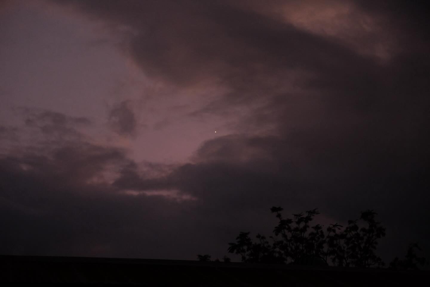 Dark storm clouds above a tree line
