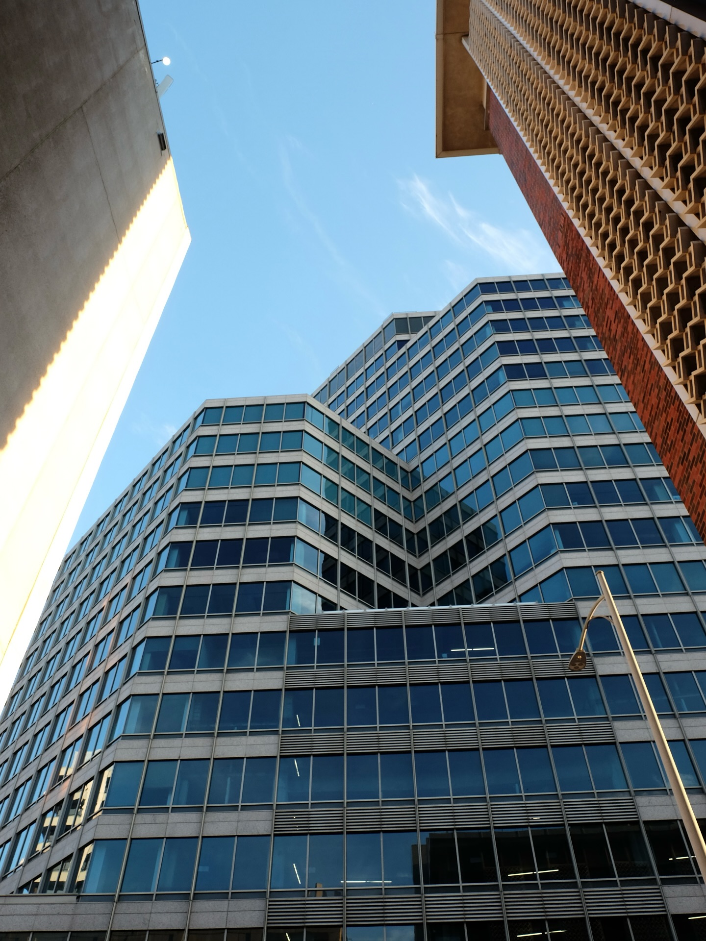 Looking up at the stepped glass corners of two office buildings